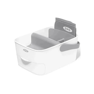 Oxo Tot Diaper Caddy in white and gray, featuring compartments for organization and a changing mat.