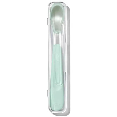 OXO Tot On-The-Go Feeding Spoon in opal color, displayed in a clear protective case.