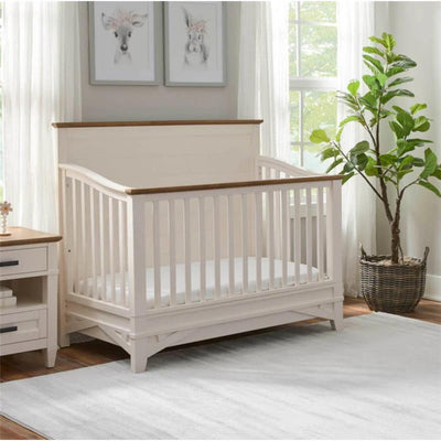 Parker House Artisan 4-in-1 Convertible Crib in a bright room, featuring a wood-paneled top and slatted sides.
