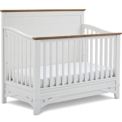 4-in-1 Convertible Crib with a white finish and natural wood accent, featuring slatted sides and a white mattress.