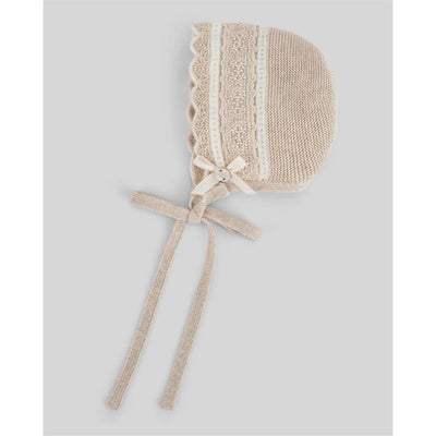 Light brown and cream knitted newborn bonnet with a decorative button and bow, featuring textured patterns and ties.