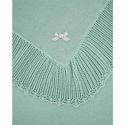 Paz Rodriguez Blanket in white and chalk pink, featuring a textured knitted edge and a decorative bow detail.