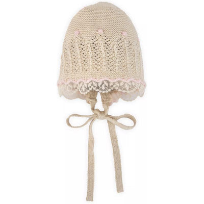 Knit newborn bonnet in light brown with chalk pink lace trim and decorative knots. Ideal for infants.