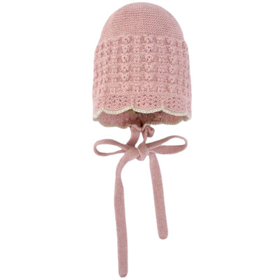 Knit newborn bonnet in cream and beige with scalloped edges and ties for secure fit. Ideal for infant photography.