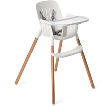High chair in white with wooden leg accents, featuring a removable tray and harness for safety.