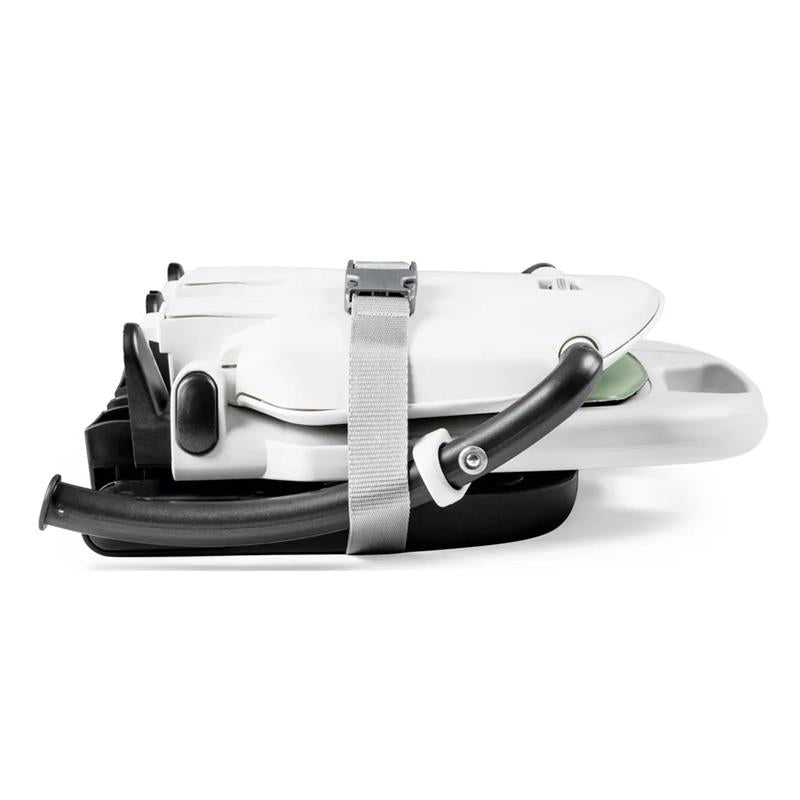 Peg Rialto Booster High Chair in Ice, shown in a folded position with a strap for secure storage.