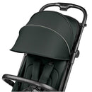 Compact Peg Volo stroller in sage green with a folded canopy, featuring a padded seat and adjustable harness.