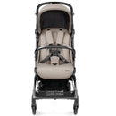 Peg Volo Compact Stroller in Misty Beige with a safety harness and spacious seat, featuring a sleek black frame and storage basket.