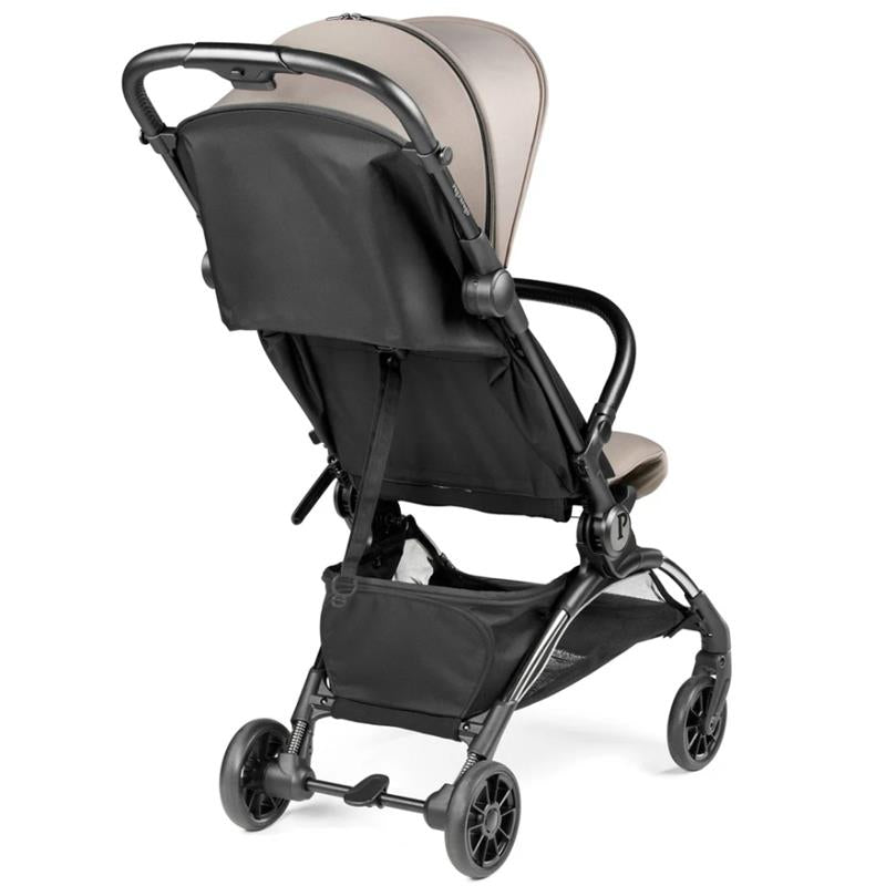 Peg Volo Compact Stroller in Misty Beige, featuring a black fabric seat back and storage basket, viewed from the rear.