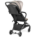 Peg Volo Compact Stroller in Misty Beige, featuring a black fabric seat back and storage basket, viewed from the rear.
