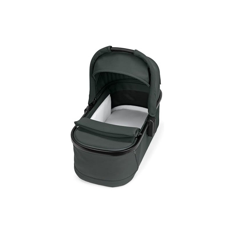Sage green Peg Perego Ypsi bassinet with a metal frame, featuring a soft white interior and a foldable canopy.
