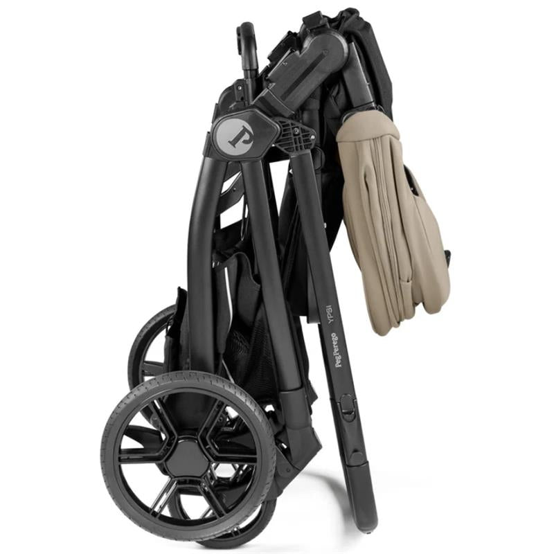 Peg YPSI Single-to-Double Stroller in Vanilla Blend, folded for compact storage, featuring black frame and tan handle.