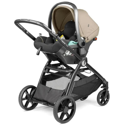PEG YPSI + Primo Viaggio Nido Travel System in Vanilla Blend, featuring a stroller with a car seat and sleek black design.