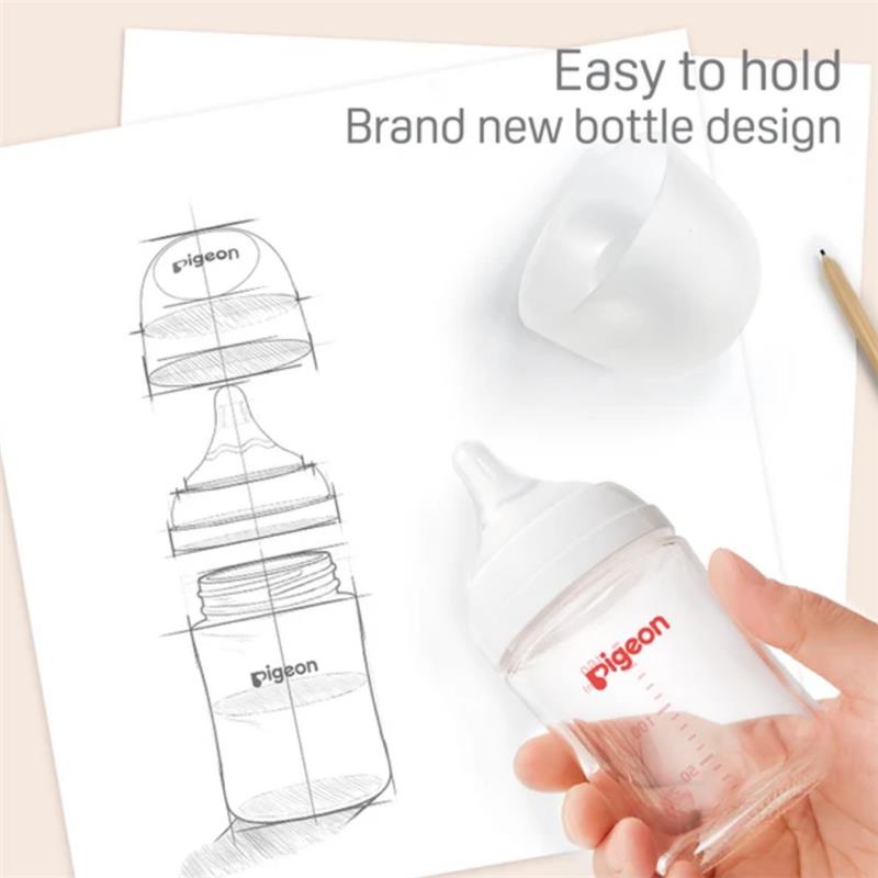 Wide neck Pigeon baby bottle in hand, featuring a clear design, with a sketch of its ergonomic shape on paper.