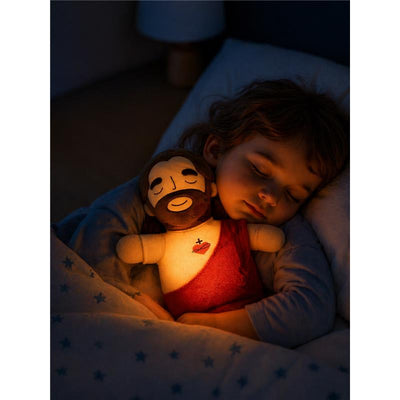 Child sleeping peacefully with the Primo Passi Jesus Comfort Plush, a soft toy depicting Jesus, designed for comfort.