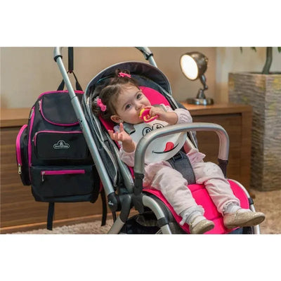 Silicone baby bib with a white face worn by a sitting baby in a stroller, holding a colorful toy, in a modern indoor setting.