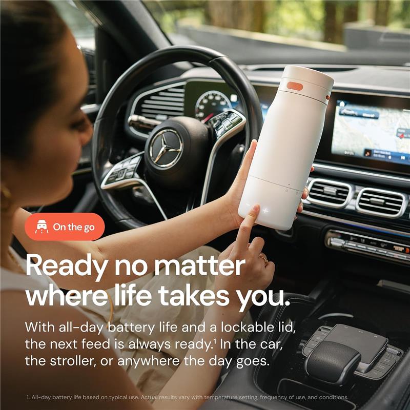Portable Quark BuubiBottle milk warmer held by a person in a car, featuring a sleek design, emphasizing convenience and battery life.