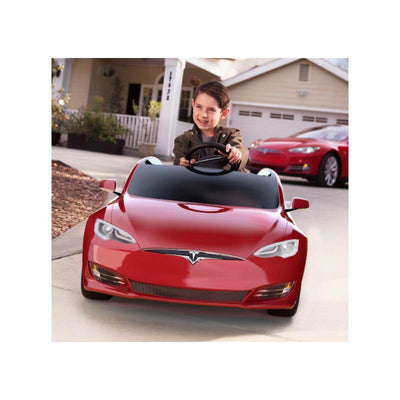 Child driving a red metallic Radio Flyer Tesla Model S for Kids in a suburban driveway.