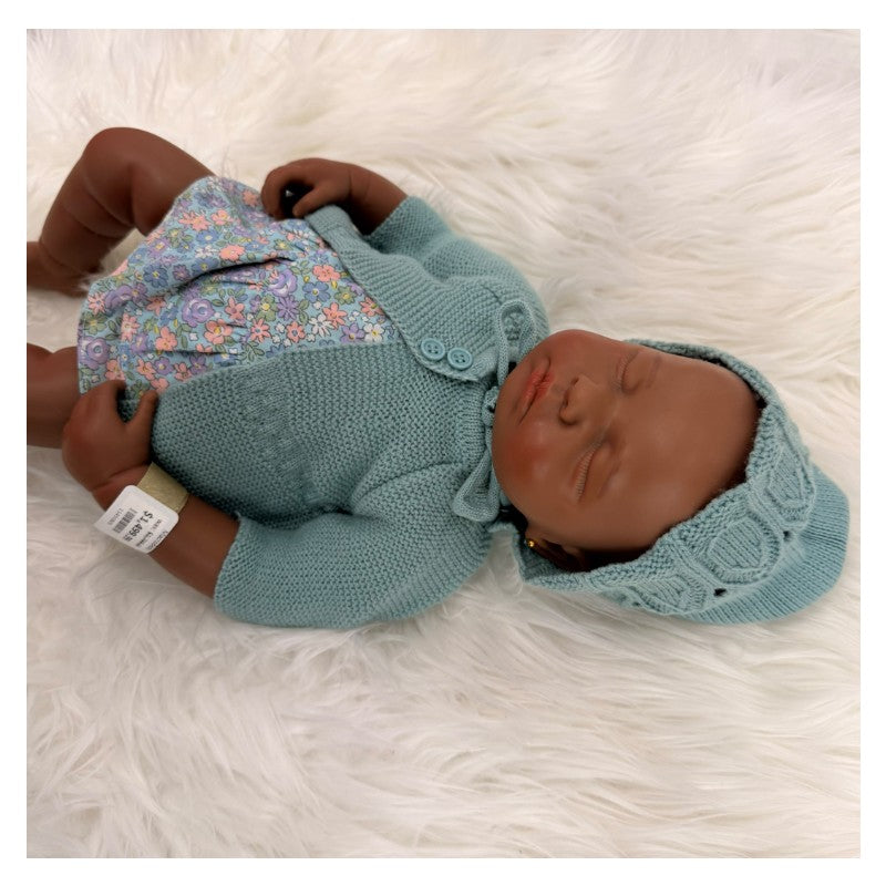 Reborn baby doll named Emily, featuring African American full silicone with a blue knitted outfit and floral dress.