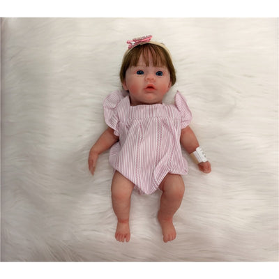Reborn Baby Doll Charlie, a full silicone doll with brown hair, wearing a pink striped onesie and a matching headband.