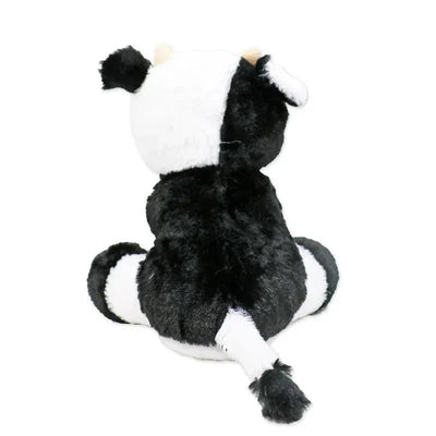 Plush toy cow with a black and white pattern, seated with a tail and ears visible from the back.