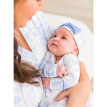 Baby in a blue butterfly-patterned knotted sleep gown and bow hat set, gazing at mother, showcasing soft fabrics.