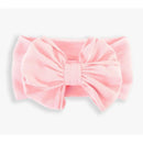 Pink headband featuring a large, textured bow, designed for young girls by Rufflebutts.