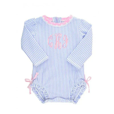 Periwinkle blue seersucker one-piece rash guard with long sleeves, pink trim, and a decorative monogram.