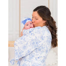 Mom kisses her baby in a floral-patterned blue and white maternity robe, while the baby wears a matching hat.