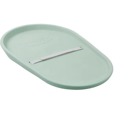Squishy baby changing pad in eucalyptus color, featuring a smooth, oval shape and a safety strap.