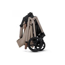 Compact Silver Cross Breez stroller in Champagne color, folded for easy storage with dark wheels and a lightweight frame.