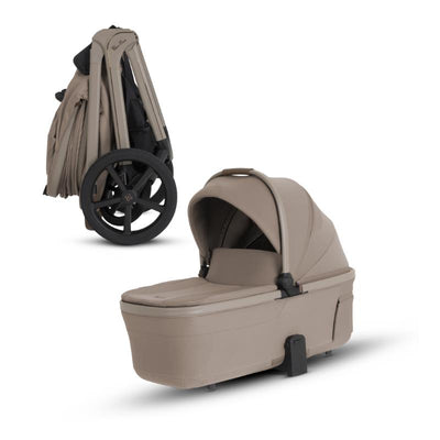 Compact Silver Cross Cove 2 bassinet in Champagne color with a smooth design and handle for easy transport.