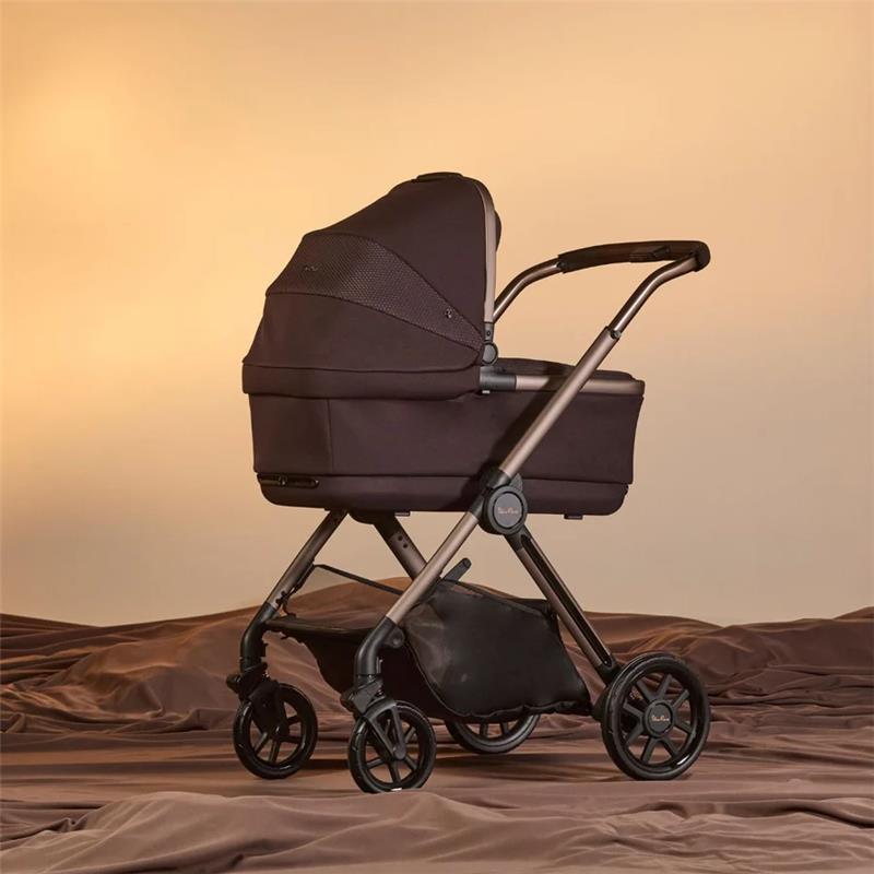 Silver Cross Reef 2 Folding Bassinet in Ganache color, featuring a sturdy frame and four wheels, set against a soft beige background.