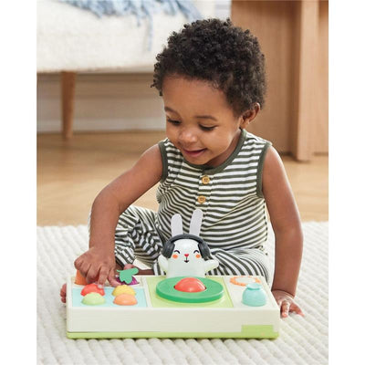 A toddler plays with the Skip Hop Baby Musical DJ Set Toy, featuring a rabbit character, colorful buttons, and lights.
