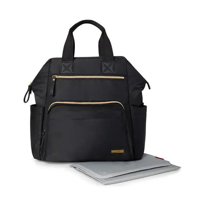 Wide open black diaper backpack with gold zippers and front pockets, accompanied by a gray changing mat.
