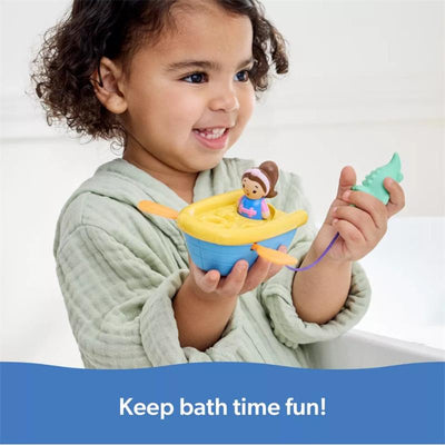 Child in a green bathrobe joyfully holds a colorful Spin Master Row Your Boat Bath Toy with a girl figure and a play accessory.