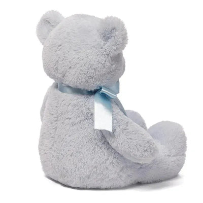 Soft blue teddy bear plush toy with a satin ribbon around its neck, sitting upright.