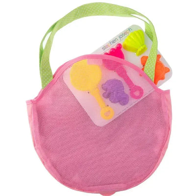 Pink mesh beach tote bag containing colorful sand toys including a yellow shovel, pink rake, and purple mold.