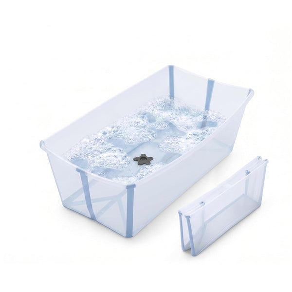 Stokke Flexi Bath Tub X-Large in Ocean Blue, filled with water and bubbles, with a folding insert beside it.