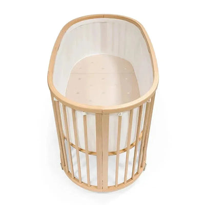 White mesh liner for the Stokke Sleepi crib, featuring a curved wooden frame with vertical slats and a soft interior.
