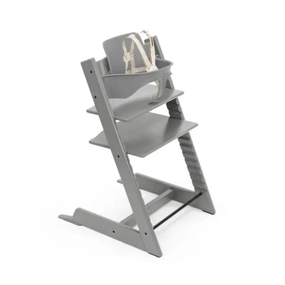 Stokke Tripp Trapp high chair in Storm Grey with adjustable seating and safety harness for children.