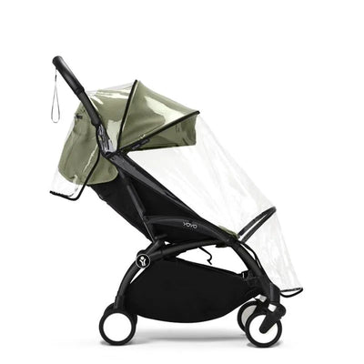 Black Yoyo 6+ rain cover attached to a stroller, featuring a transparent front and a green canopy.