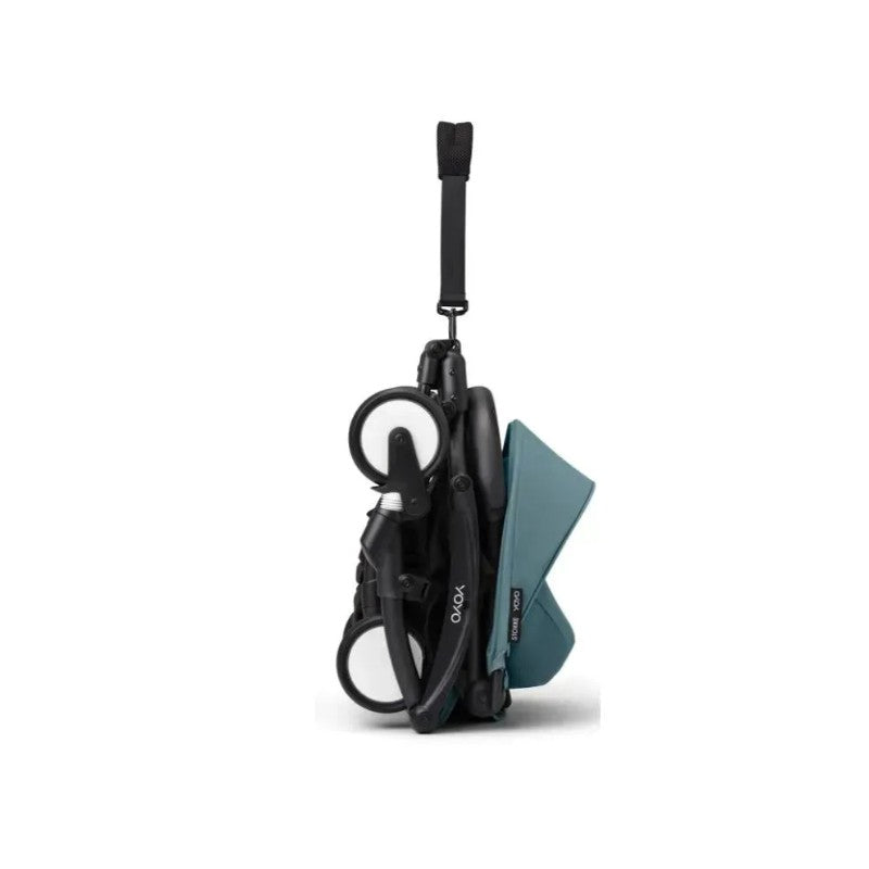 Stokke Yoyo³ stroller in a folded position featuring a black frame and aqua-colored leg rest.