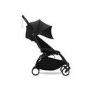 Stokke Yoyo³ 6+ stroller with a black frame, folded with a black canopy and leg rest. Compact design for easy transport.