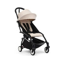 Stokke Yoyo³ stroller in black frame with a beige seat, designed for children 6 months and up.