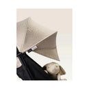Stokke Yoyo³ Stroller with a beige canopy and black frame, featuring a plush bunny toy in the seat.