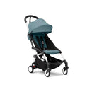 Stokke Yoyo³ stroller with a white frame and aqua seat, featuring a sunshade and a spacious under-seat storage.
