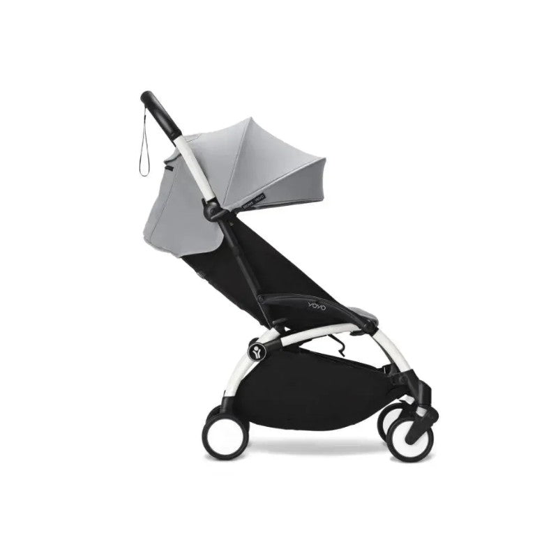 Stokke Yoyo³ stroller with white frame, stone-colored canopy, and leg rest, designed for children 6 months and up.