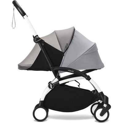 Stokke Yoyo® 0+ Newborn Pack with black mosquito net attached, featuring a gray canopy and a white frame.