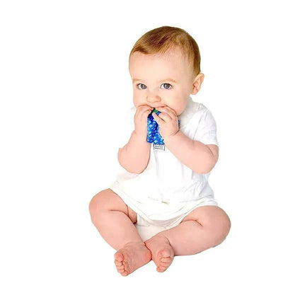 Baby sitting on a white background, chewing on a blue fish-shaped teething bib tie while wearing a white onesie.